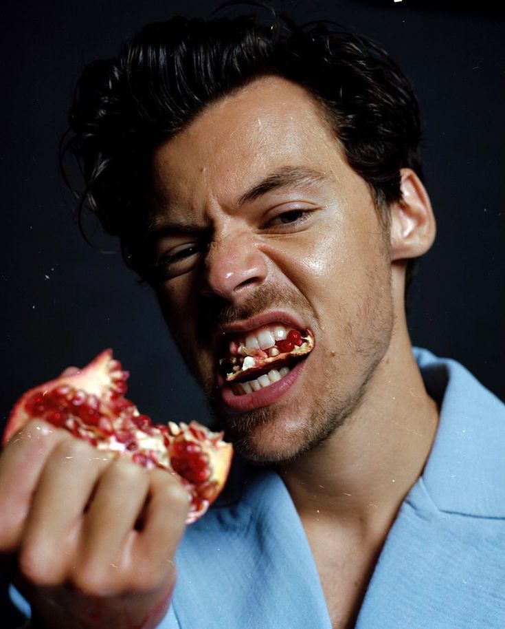 a man eating a piece of pizza with his mouth wide open and teeth missing from it