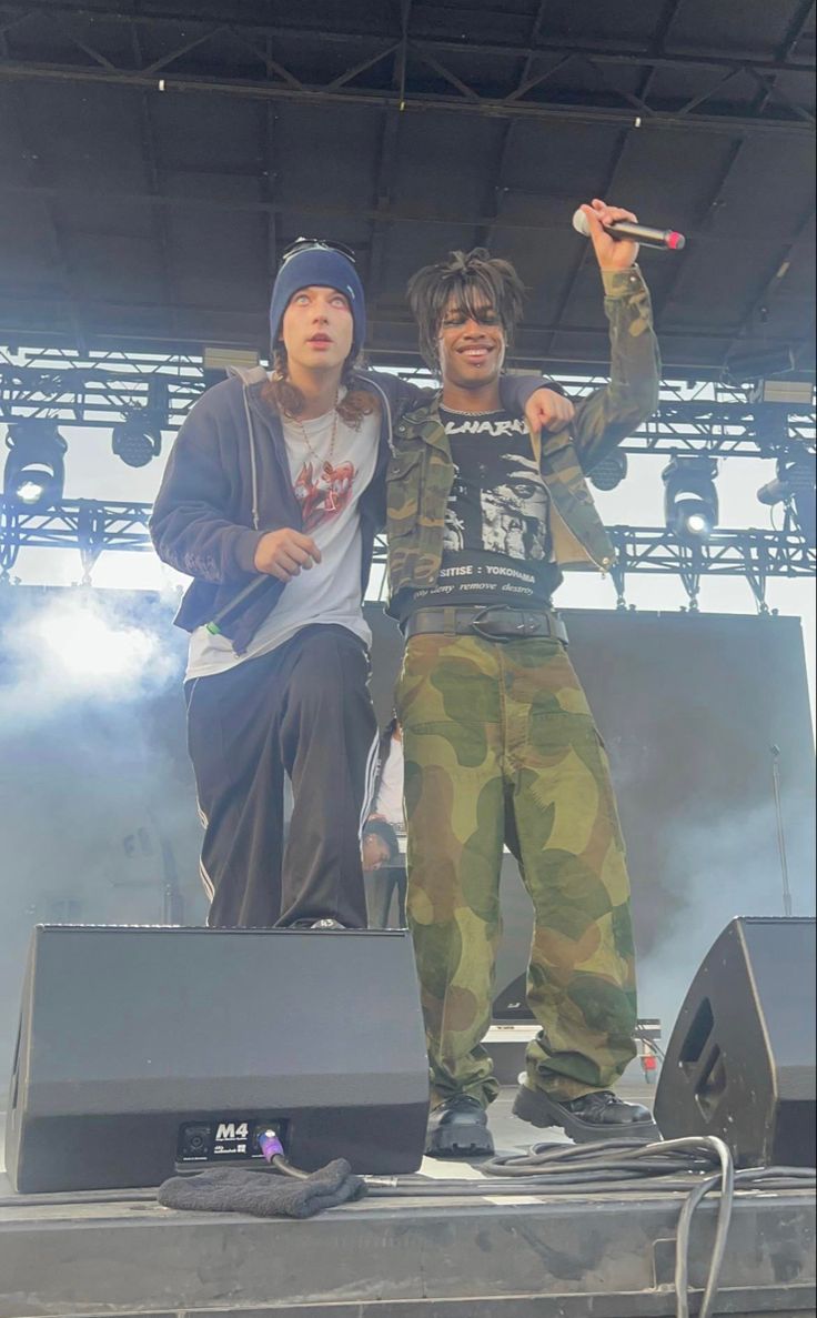 two young men standing on top of a stage