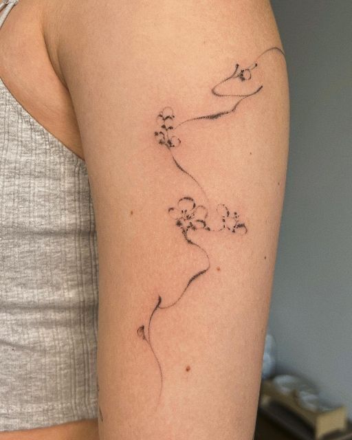 a woman's arm with a flower tattoo on the left side of her arm