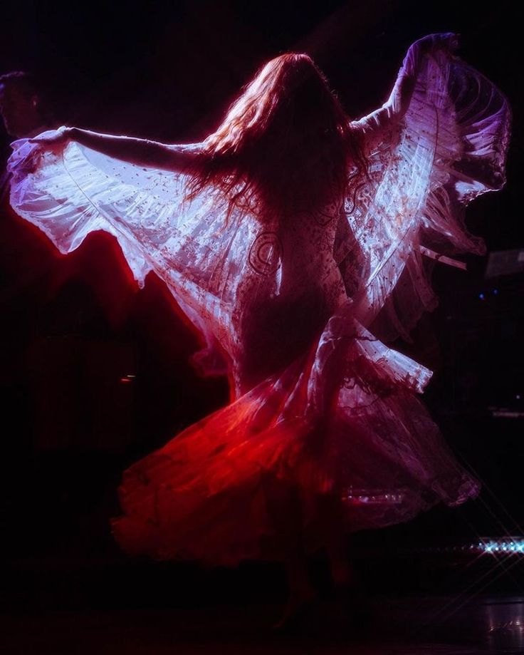 a woman in a white dress is dancing on stage