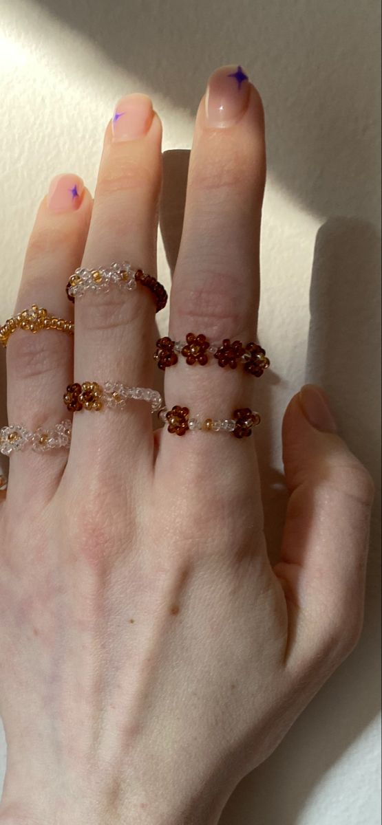 a woman's hand with five different rings on her fingers and one is wearing a diamond ring