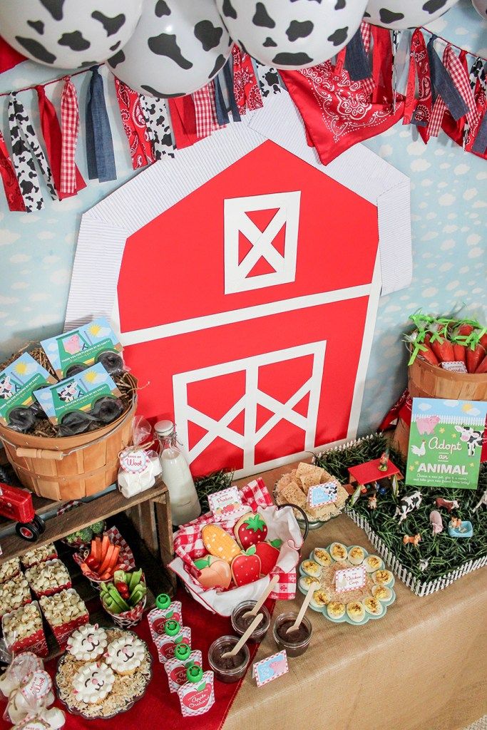 a table topped with lots of food next to a red and white barn sign on top of a wall