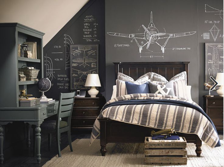 a bed room with a neatly made bed and a chalkboard wall