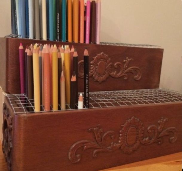 several pencils are lined up in a holder on the table next to each other