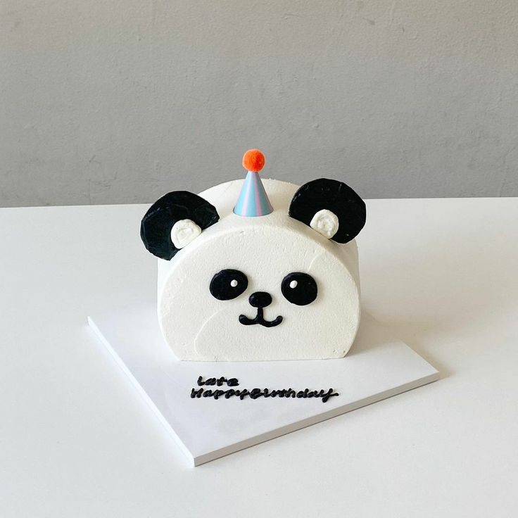 a birthday cake with a panda bear wearing a party hat on it's head