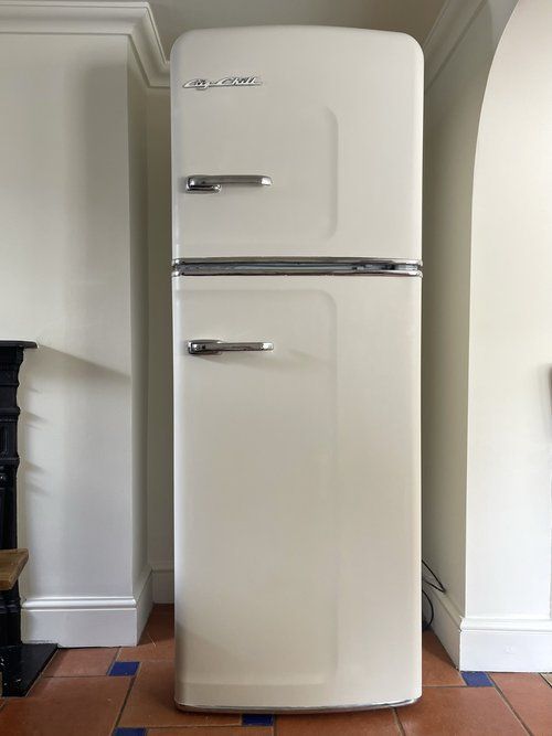 an old fashioned white refrigerator in a kitchen