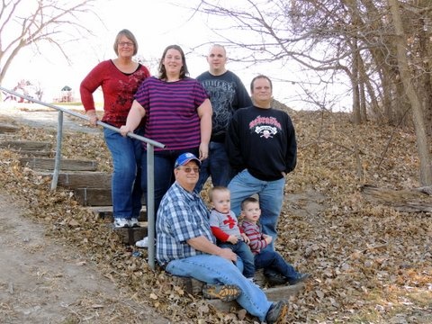 a group of people standing next to each other on a dirt path in the woods