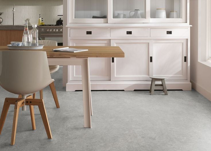 a dining room table and chairs in front of a white hutch