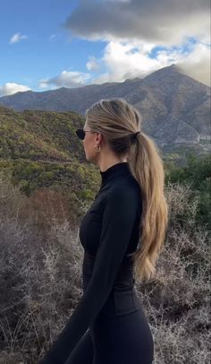 a woman with long hair walking in the desert