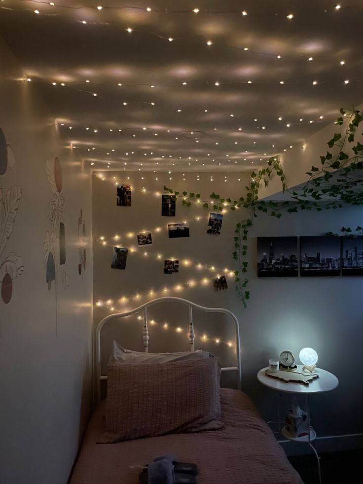 a bedroom with lights strung from the ceiling and a small bed in front of it