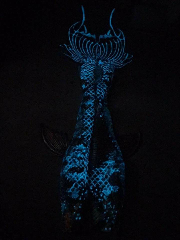 a blue dragon statue is lit up in the dark