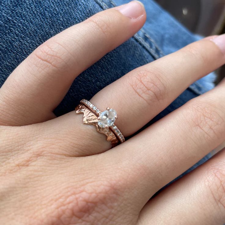 a close up of a person's hand with a ring on their finger and an engagement band