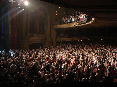 a large group of people standing in front of a stage