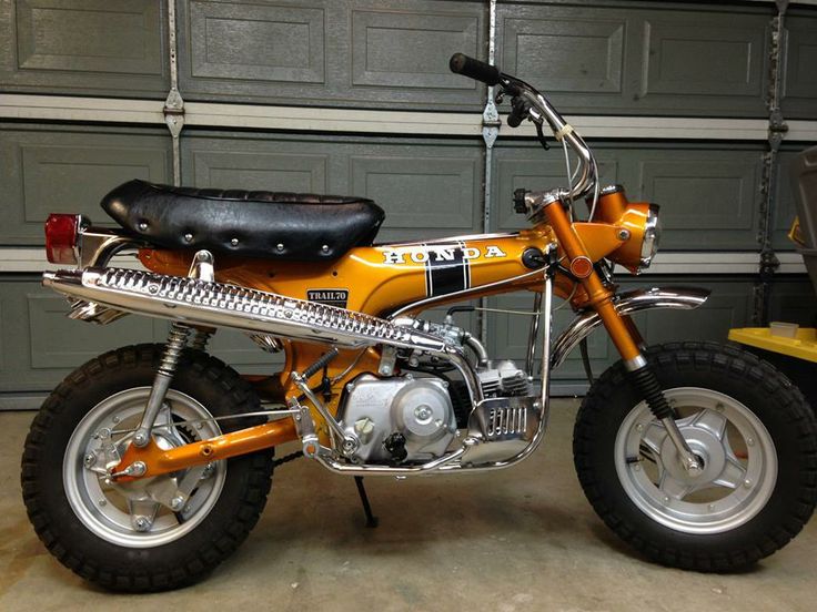 an orange dirt bike parked in front of a garage door