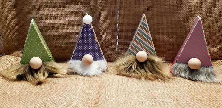 three small gnome hats with long hair on them