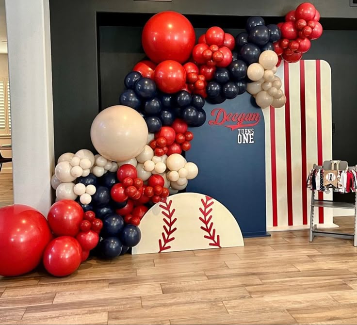 balloons are arranged in the shape of baseballs and bats on display at a sports themed birthday party