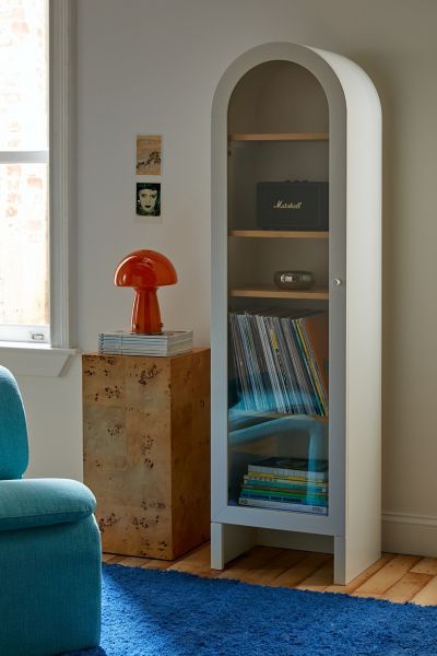 a room with a blue chair and a book shelf