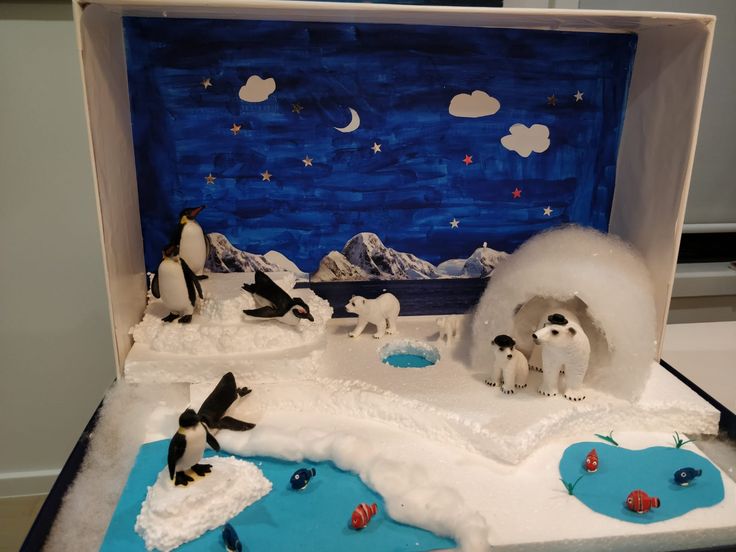 an open box with penguins and polar bears in the snow, on top of ice