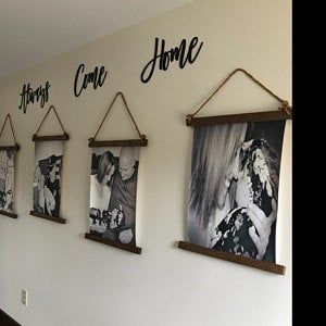 a wall with pictures hanging on it and the words home are in black letters above them