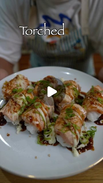 a white plate topped with sushi covered in sauce