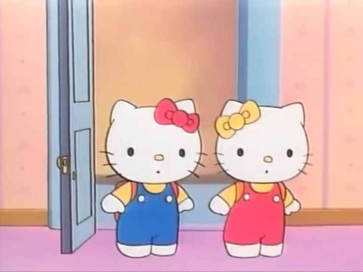 two hello kitty dolls standing next to each other in front of an open door with pink walls