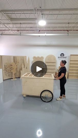 a woman standing next to a cart in a room