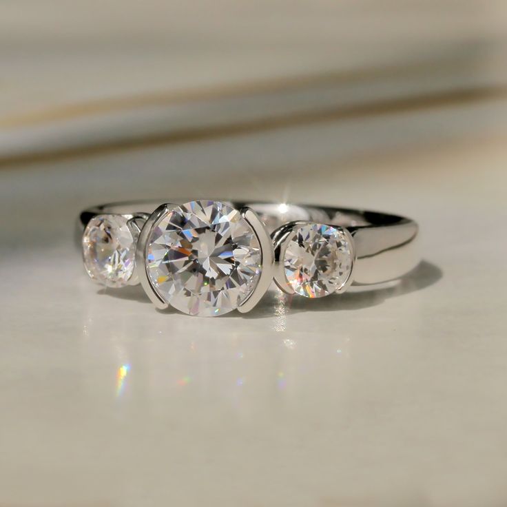 three stone diamond ring sitting on top of a counter