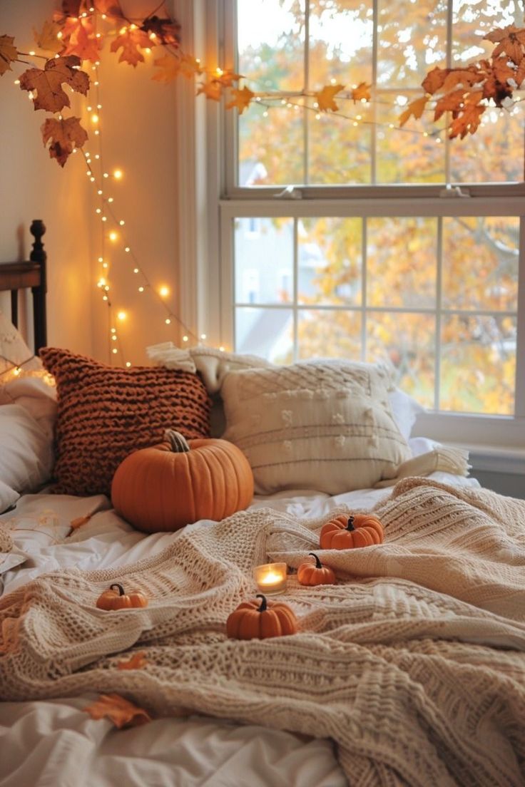 a bed with pumpkins and lights on the headboard in front of a window