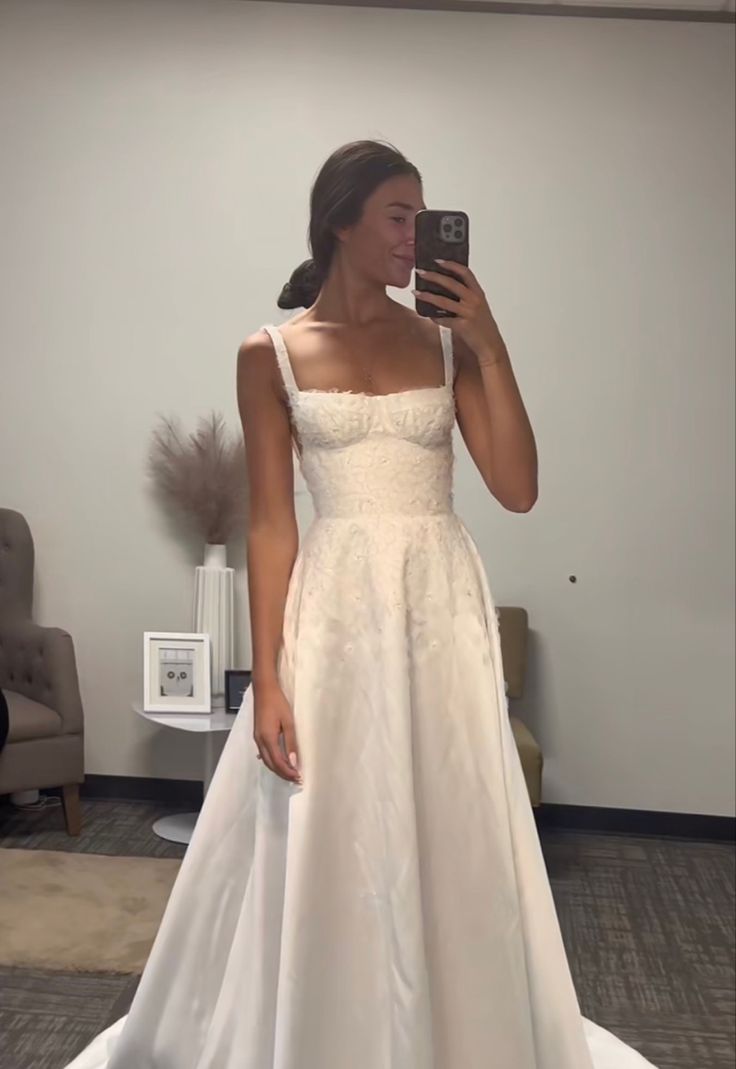 a woman in a wedding dress taking a selfie