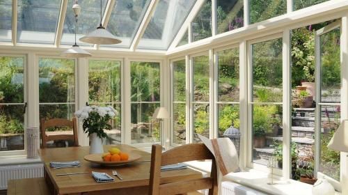 a dining room table and chairs in front of a large window with lots of windows