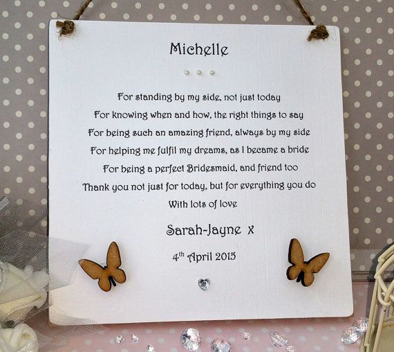 a sign with two butterflies hanging from it's sides on a table next to other items