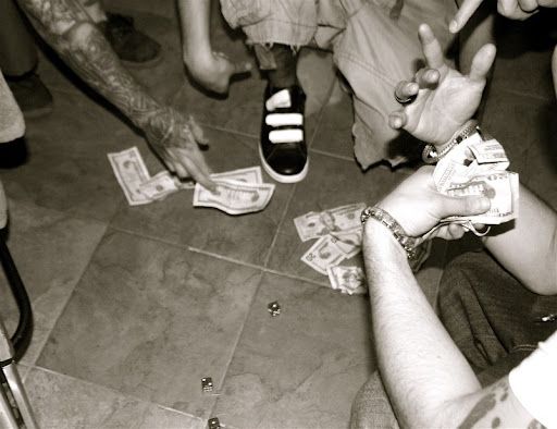 a group of people sitting around each other on the floor with money in their hands