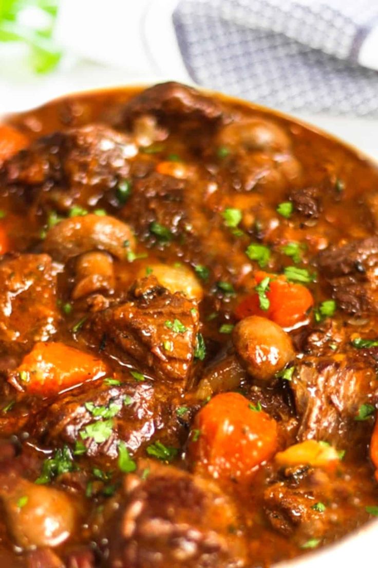 a white bowl filled with meat and carrots