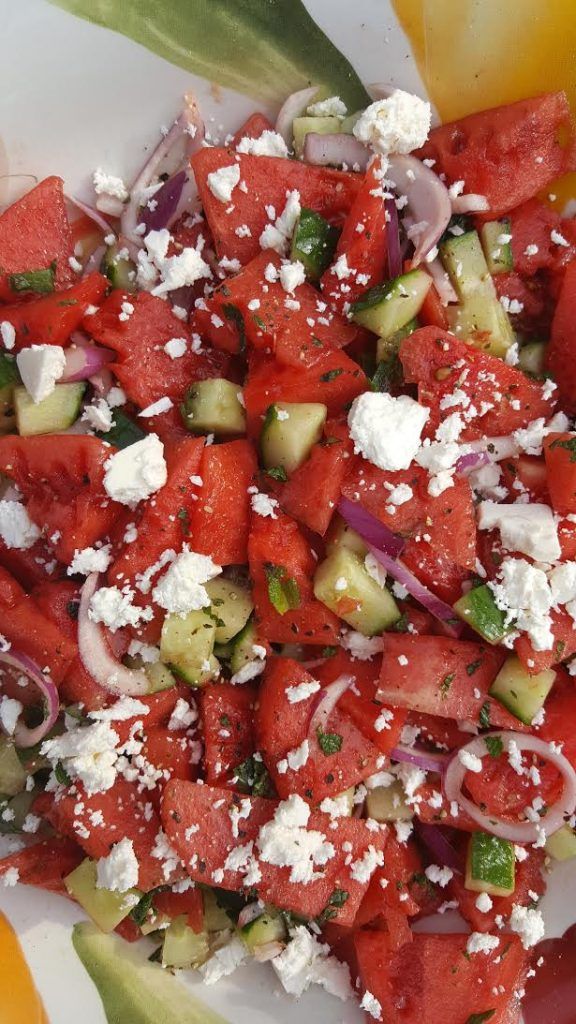 watermelon and cucumber salad with feta cheese on the top is ready to be eaten