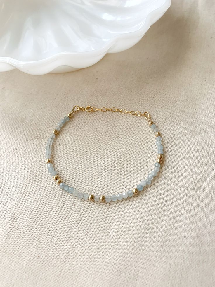 "Please review the sizing guide below before purchase. This sparkly light blue gemstone bracelet will add a pop of gemmy color to your bracelet stack! These genuine Aquamarine gems really sparkle! It looks beautiful layered with other bracelets, or worn solo! * 3mm genuine Aquamarine gemstones * 14K Gold Filled or 925 Sterling Silver accents * 14/20 GF or 925 stamp for authenticity * Choose your length (each bracelet has a 1\" extender chain for adjustable sizing.) * Made with all hypoallergenic Simple Bracelet Making Ideas, Dainty Beaded Bracelets, Blue Bracelet Beads, Light Blue Bracelet, Women March, Light Blue Gemstone, Blue Gemstone Bracelet, Aquamarine Bracelet, Basic Jewelry