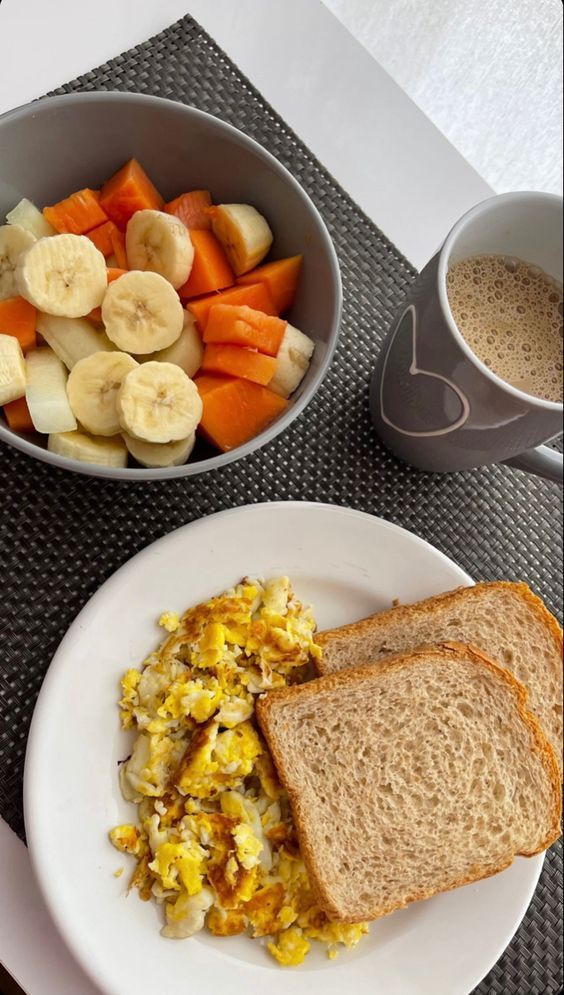 a breakfast plate with toast, eggs, and fruit on it next to a cup of coffee