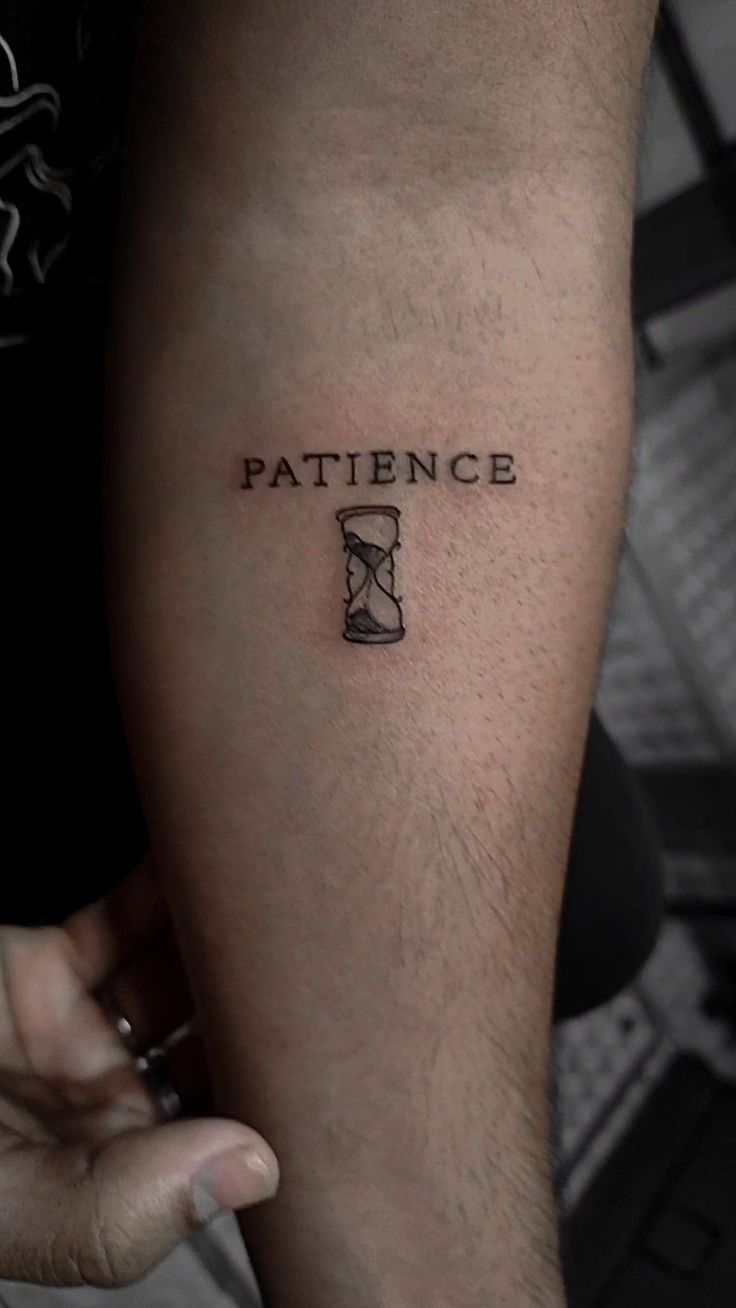 a man with a tattoo on his arm that says,'patience'and an hourglass