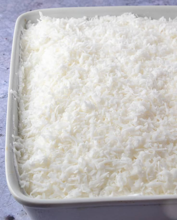 a white dish filled with rice on top of a table