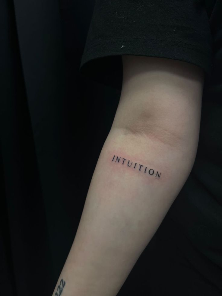 a person with a small tattoo on their arm that says,'injution '