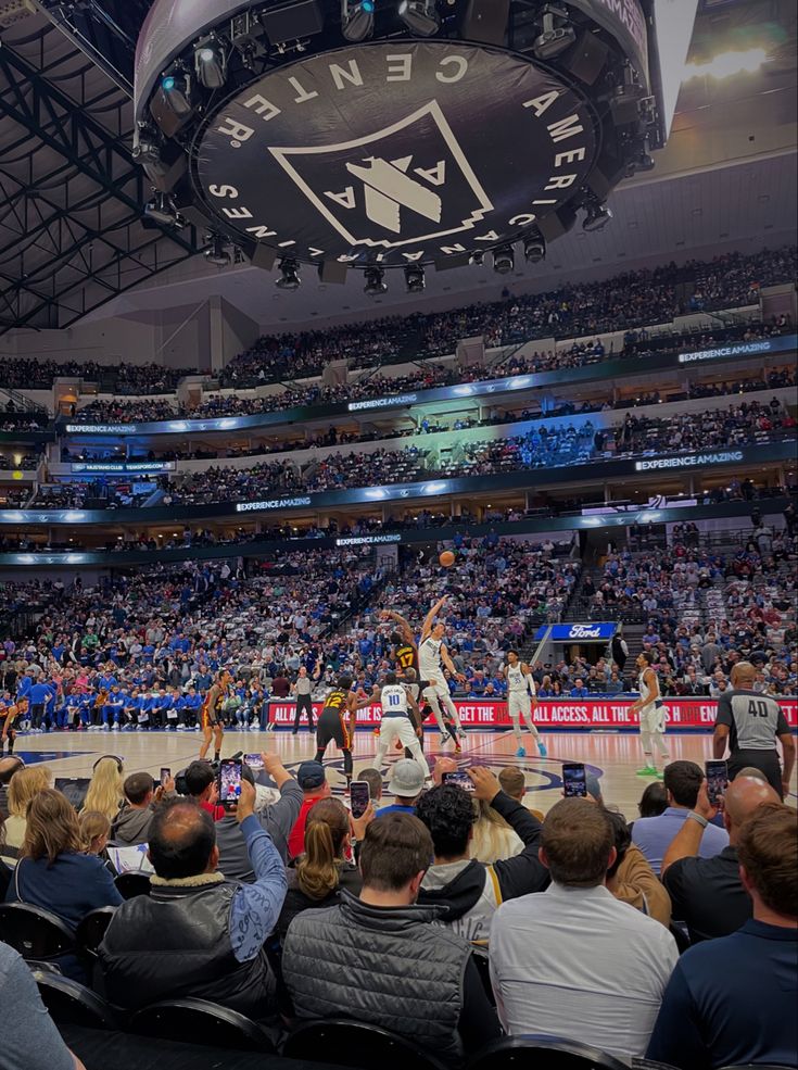 a basketball game is being played in an arena with people sitting on the sidelines