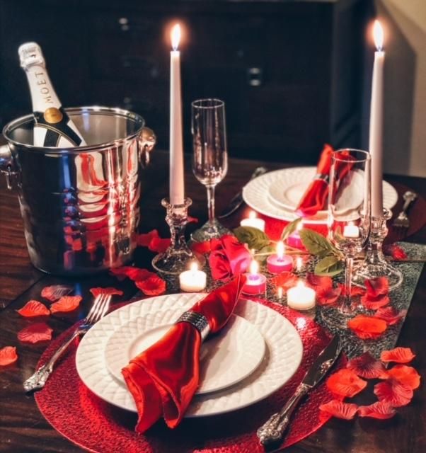 the table is set with candles, plates and silverware for an elegant valentine's day dinner