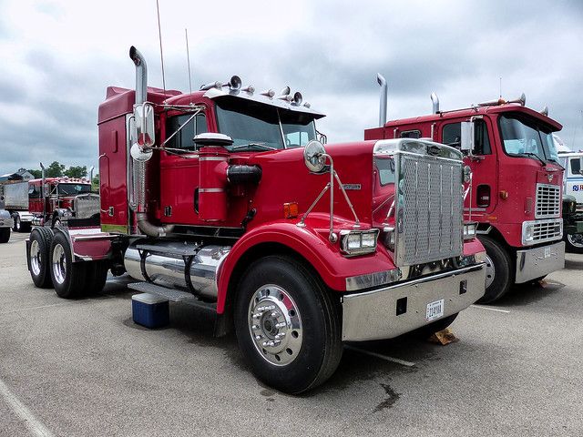 a red semi truck parked in a parking lot