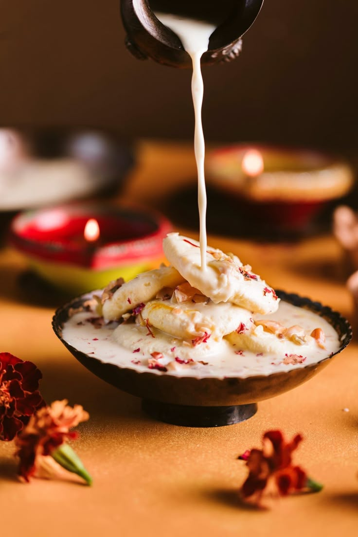 a bowl filled with bananas and cream being drizzled on top of it