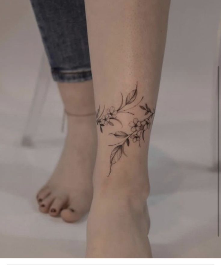 a woman's foot with a flower tattoo on the left side of her leg