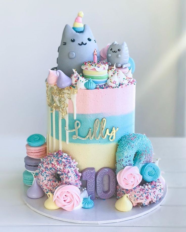 a birthday cake decorated with sprinkles, frosting, and cats on top