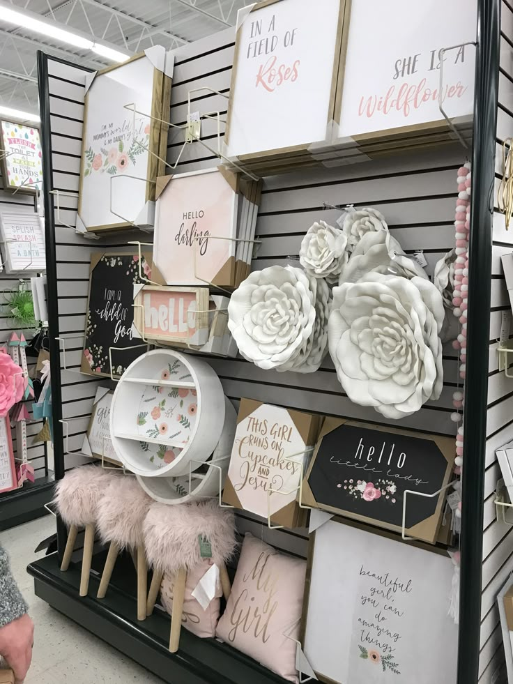 there are many items on the shelves in this store that is decorated with pink and white flowers