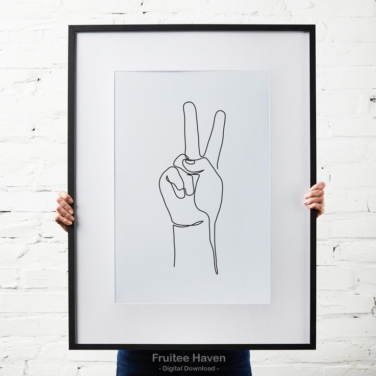 a person holding up a black and white print with the word peace written in it