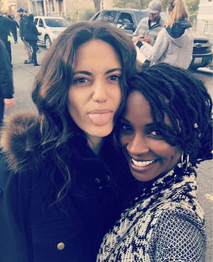 two women standing next to each other in the street