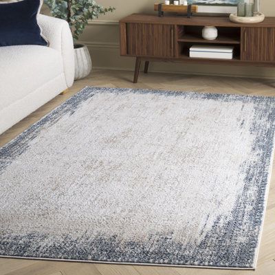 a living room with a white couch and blue rug