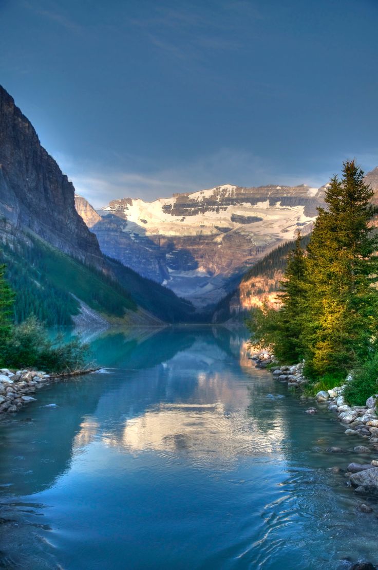 a river running through a valley surrounded by mountains